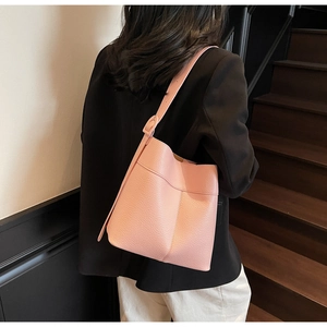 Detail of pink lychee grain leather bucket bag showing side texture and strap