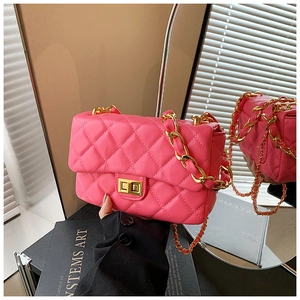 Close-up of pink quilted crossbody bag with gold metal lock and chain strap details