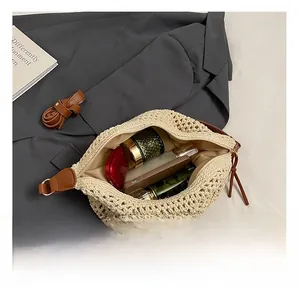 Top view of spacious straw shoulder bag with leather straps and daily essentials inside