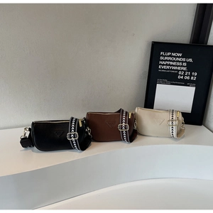 Three leather saddle bags in black, brown and beige with patterned wide shoulder straps