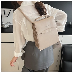 Model wearing a minimalist cream PU leather handbag with elegant wavy flap and top handle