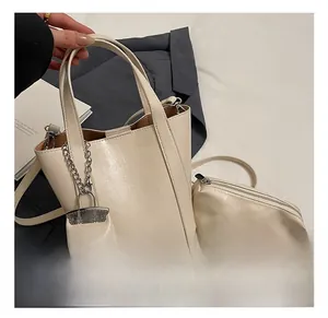 Detail of beige bucket bag set with matching coin purse and stylish silver chain charm