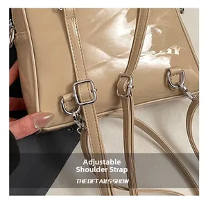 Close-up of beige patent leather bag with adjustable silver strap buckle and metal hook