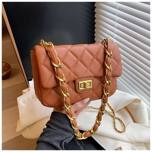 Detail of caramel quilted leather flap bag featuring a golden twist lock and chain strap