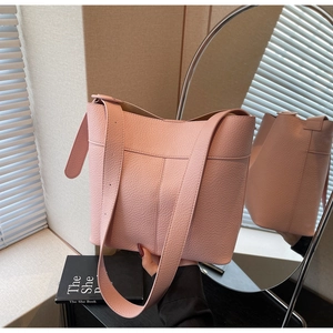 Detail of pink lychee textured bucket bag with wide shoulder strap in reflection