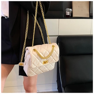 Detail of cream quilted crossbody bag with gold chain strap and metal turn-lock