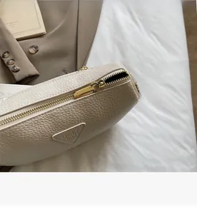 Detail of smooth gold zipper and lychee grain leather texture on chic pillow bag