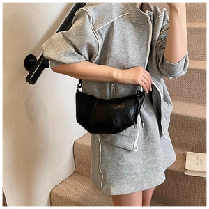 Detail of black crescent croissant bag with pleated stitching and knotted leather shoulder strap