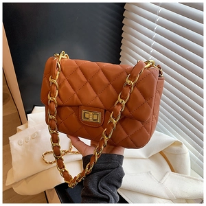 Detail of a dark brown quilted shoulder bag featuring golden chain and metal turn-lock closure