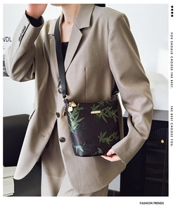 Detail of waterproof nylon crossbody bag with green bamboo leaf print and gold hardware