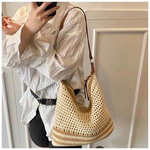Mirror selfie showing the beige hollow crochet shoulder bag with brown leather strap