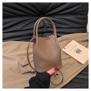 Detailed texture of brown pebble leather bucket bag with top handle and shoulder strap