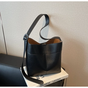 Detail of black pebbled leather bucket bag showing fine texture and interior lining