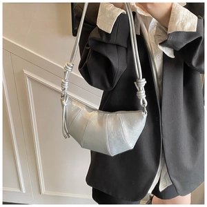 Detail of silver croissant bag with pleated design and signature knotted shoulder strap