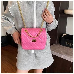 Detailed view of pink quilted chain bag with gold rectangular turn-lock buckle
