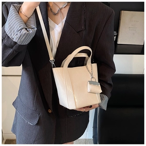 Close-up of beige PU leather tote bag with mini zipper pouch and detachable shoulder strap