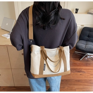 Detail of adjustable brown shoulder strap and canvas texture on stylish tote bag