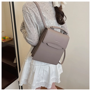 Detail of taupe synthetic leather backpack with metal clasp and top handle for women