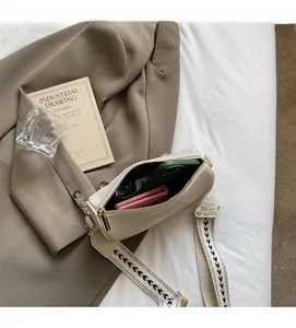 Detail view of beige crossbody bag showing practical inner space and geometric wide strap