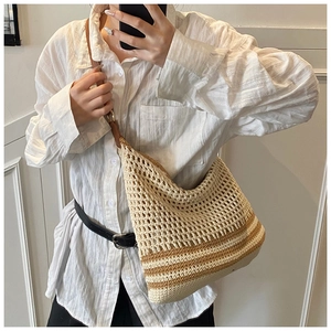 Detail of hand-woven beige crochet tote bag with brown stripes and mesh texture