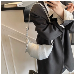 Silver metallic croissant bag detail with side knot and soft leather texture