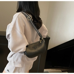 Detail of black pebbled leather pillow bag with geometric pattern wide shoulder strap