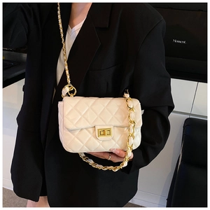 Detailed close-up of a white quilted crossbody bag with a gold metal twist-lock and chain strap
