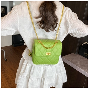 Detail of lime green quilted mini backpack with golden chain straps on white dress