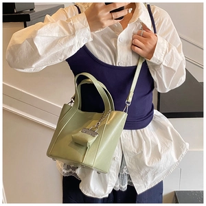 Detail of avocado green bucket bag featuring a detachable mini coin purse and leather texture