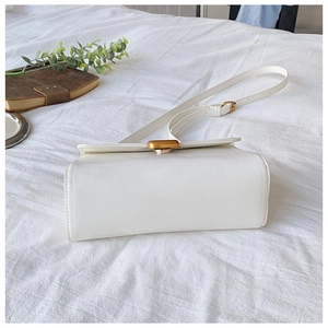 Detailansicht der weißen eckigen Umhängetasche mit elegantem Goldverschluss und Riemen