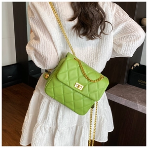 Model wearing bright green quilted crossbody bag with gold chain strap and turn-lock