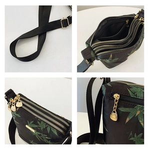 Detail view of multi-layer zippers and floral nylon fabric on the crossbody bag