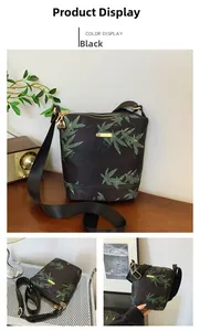 Detail of black waterproof nylon bucket bag featuring green leaf pattern and gold zippers