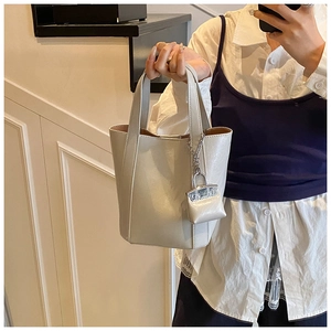 Detail of white tote bag with matching mini pouch charm and round dual handles