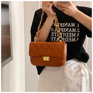 Detail of brown quilted faux leather bag with golden turn-lock and chain strap
