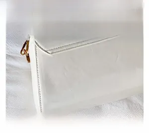 Detailansicht der weißen Leder-Umhängetasche mit feiner Naht und goldener Metallschnalle