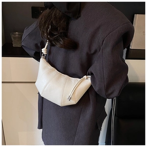 Detailed view of the pleated leather crescent bag featuring a knotted thin shoulder strap