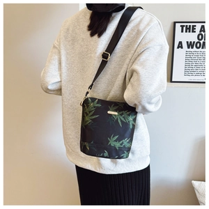Rear view of model wearing a black floral nylon crossbody bag with adjustable strap
