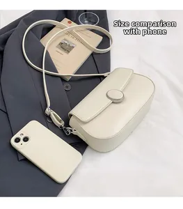 Detail of cream faux leather shoulder bag with pebble texture and magnetic buckle