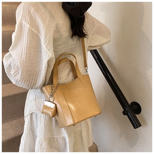 Beige tote bag with matching mini coin purse hanging on the side and adjustable strap