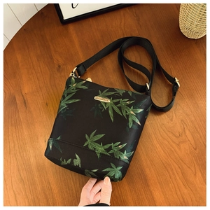 Detail view of leaf pattern nylon crossbody bag with gold hardware and logo plate