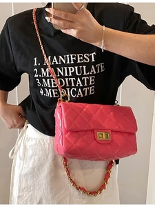 Pink quilted leather crossbody bag with gold chain strap shown on a model