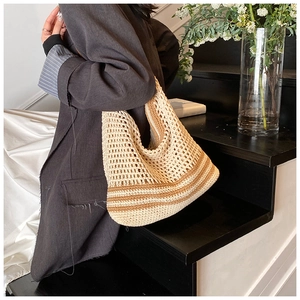 Detail view of handmade woven beach tote bag with beige and brown crochet stripes