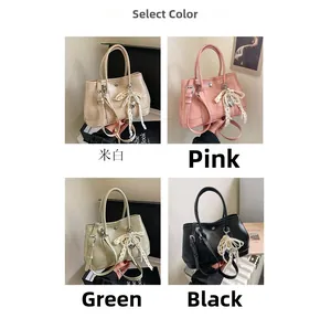 Détail de sacs seaux élégants en crème, rose, vert et noir avec des breloques en nœud rose