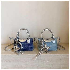 Detail of mini denim handbags in blue with silver metallic handles and bow logo