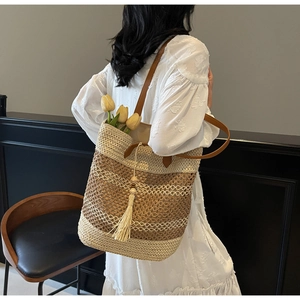 Détail du sac cabas en paille tissé main avec lanières en cuir et pompon beige
