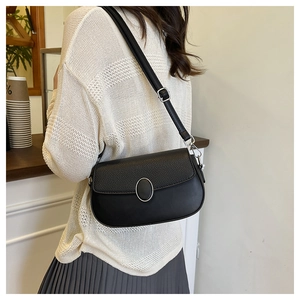 Detail view of black pebble leather shoulder bag featuring silver buckle and adjustable strap