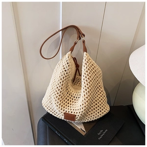 Detail of hollow woven tote bag in cream white with brown faux leather strap and zipper