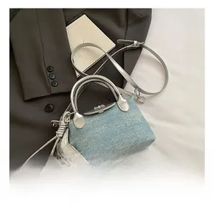 Detail of light blue glitter texture handbag with silver handle and star charm accessory
