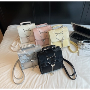 Détail de cinq mini sacs tendance avec lacets croisés et breloques papillon en perle